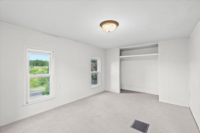 unfurnished bedroom featuring carpet floors, a closet, and visible vents