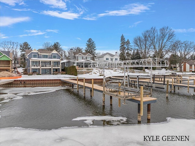 view of dock featuring a water view, boat lift, and a residential view