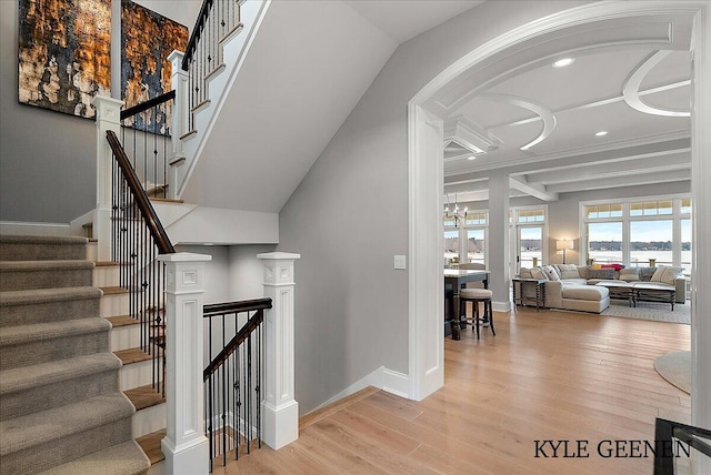staircase featuring a chandelier, baseboards, and wood finished floors