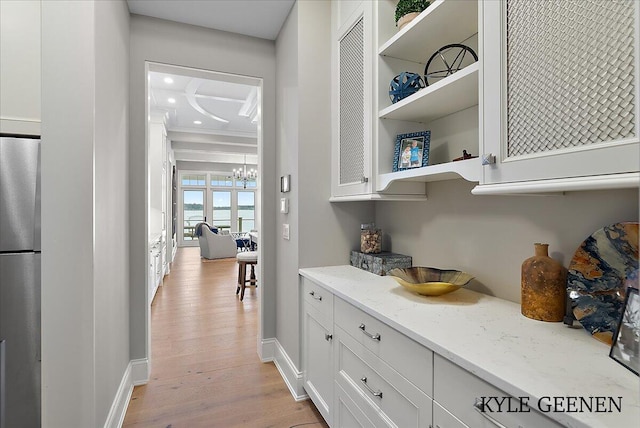 bar with light wood-style flooring, recessed lighting, a notable chandelier, baseboards, and freestanding refrigerator