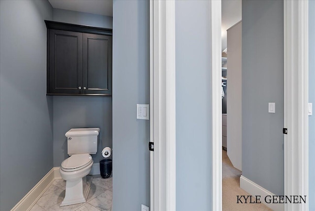 bathroom featuring toilet and baseboards