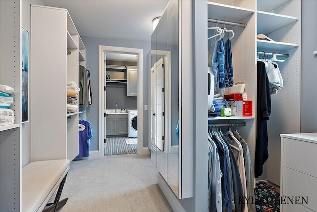 walk in closet featuring carpet, washer / clothes dryer, and a sink