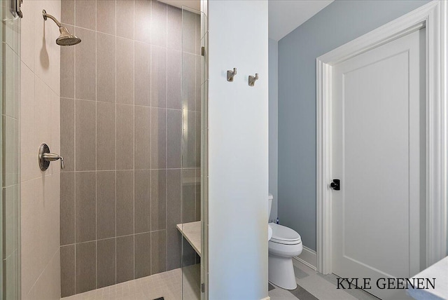 bathroom featuring a tile shower and toilet