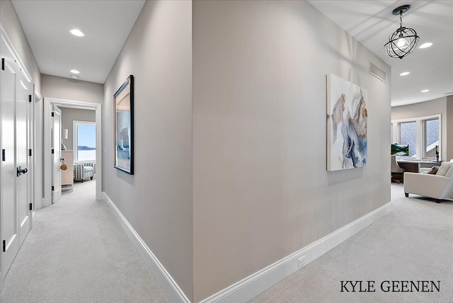 hallway featuring recessed lighting, light carpet, visible vents, and baseboards