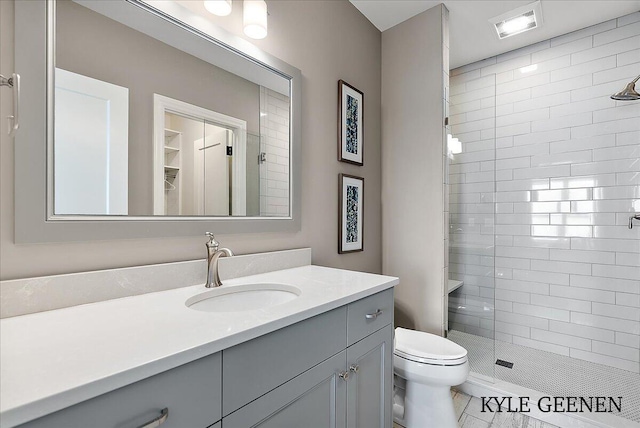 bathroom with toilet, a stall shower, visible vents, and vanity