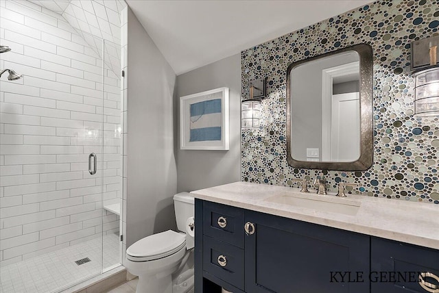 bathroom featuring a stall shower, vaulted ceiling, vanity, and toilet