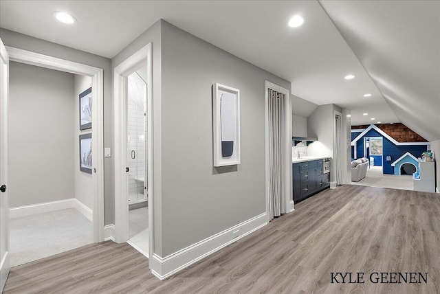 additional living space with vaulted ceiling, light wood-type flooring, baseboards, and recessed lighting
