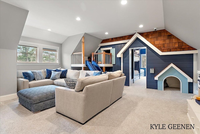 living room with lofted ceiling, wood walls, and carpet flooring