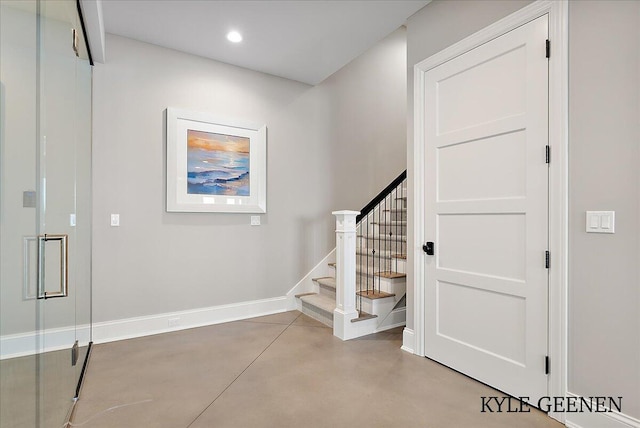 staircase featuring finished concrete floors, baseboards, and recessed lighting