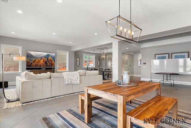 dining space featuring concrete flooring, recessed lighting, baseboards, and an inviting chandelier