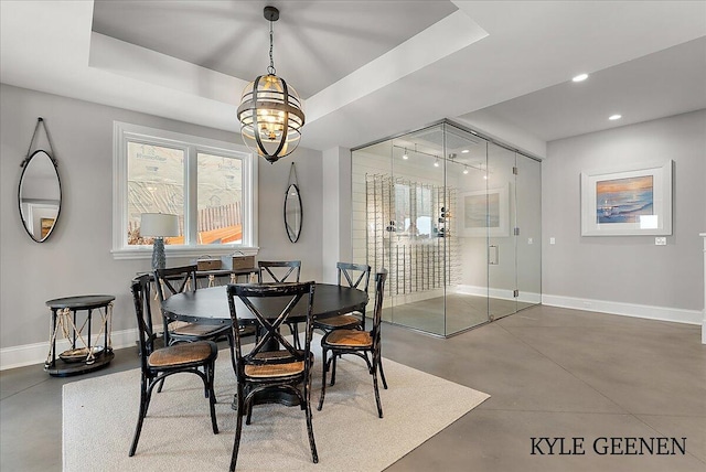 dining room featuring a tray ceiling, concrete floors, recessed lighting, and baseboards