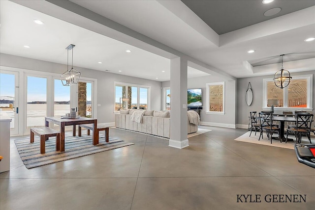 dining area with recessed lighting, a tray ceiling, finished concrete flooring, and baseboards