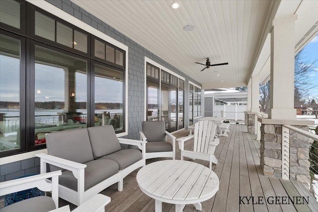 wooden terrace featuring ceiling fan and an outdoor living space