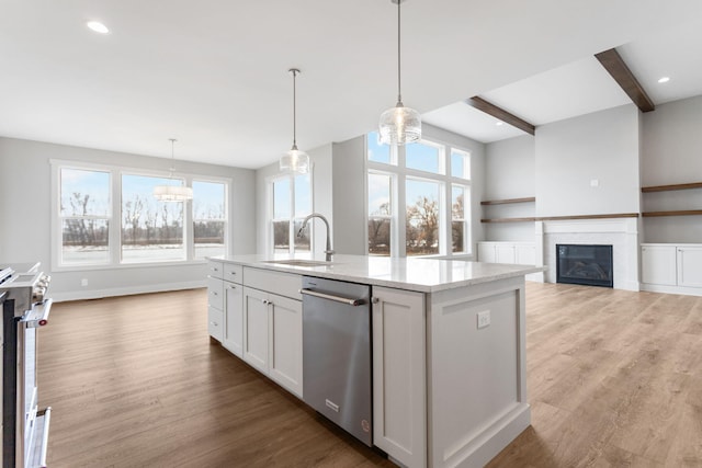 kitchen featuring a kitchen island with sink, stainless steel appliances, a sink, and wood finished floors