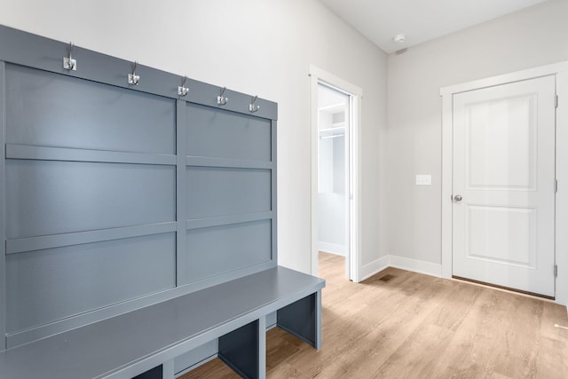 mudroom with light wood finished floors and baseboards