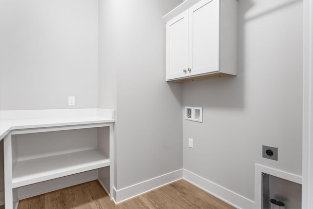 washroom with hookup for an electric dryer, washer hookup, wood finished floors, baseboards, and cabinet space