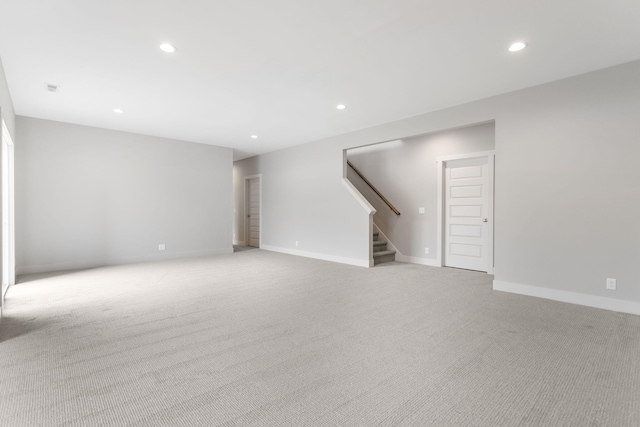 empty room featuring stairs, baseboards, light colored carpet, and recessed lighting