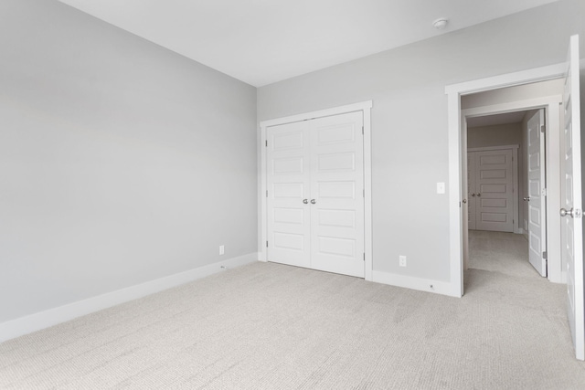 unfurnished bedroom featuring carpet floors, a closet, and baseboards