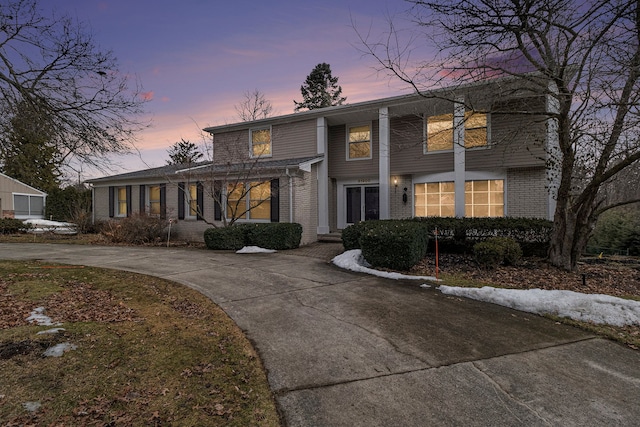 view of front of property featuring concrete driveway and brick siding