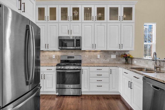 kitchen with stainless steel appliances, white cabinets, a sink, and dark wood-style floors