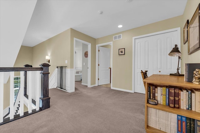 interior space featuring visible vents, carpet, an upstairs landing, and baseboards