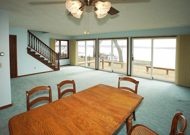 dining area with carpet, baseboards, and stairs