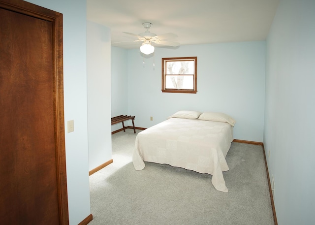 carpeted bedroom with a ceiling fan and baseboards