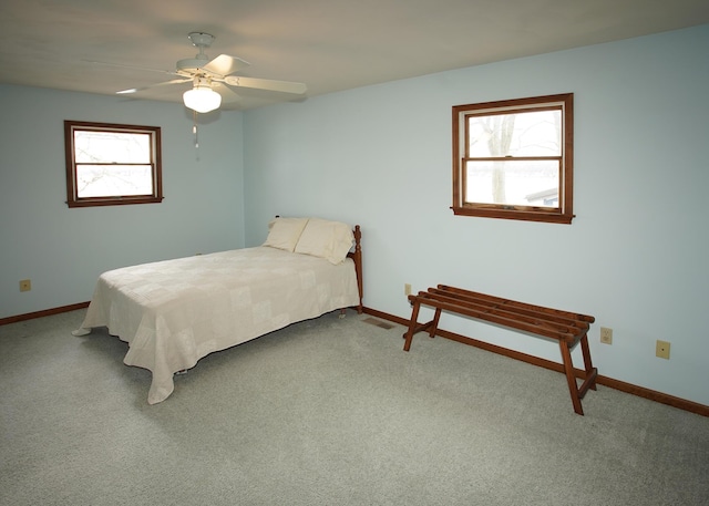 carpeted bedroom with a ceiling fan, visible vents, and baseboards