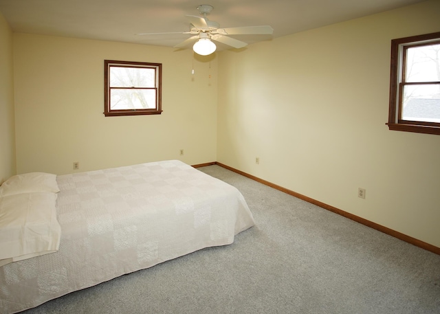 unfurnished bedroom with a ceiling fan, baseboards, and carpet flooring