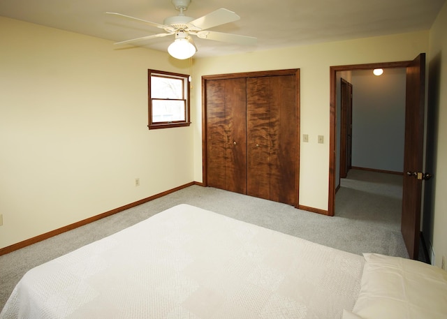 carpeted bedroom with ceiling fan, a closet, and baseboards