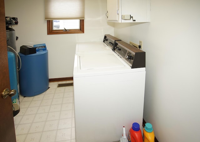 laundry room featuring washer and clothes dryer, light floors, visible vents, cabinet space, and baseboards