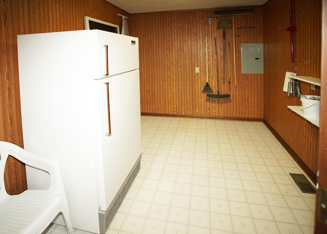 kitchen with visible vents, light countertops, freestanding refrigerator, electric panel, and light floors