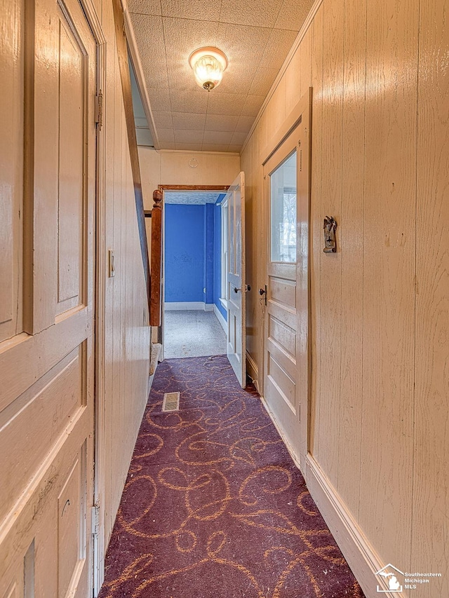 hallway with wood walls