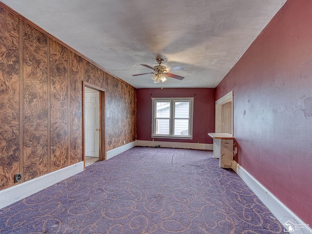 unfurnished living room with a ceiling fan, carpet flooring, and baseboards