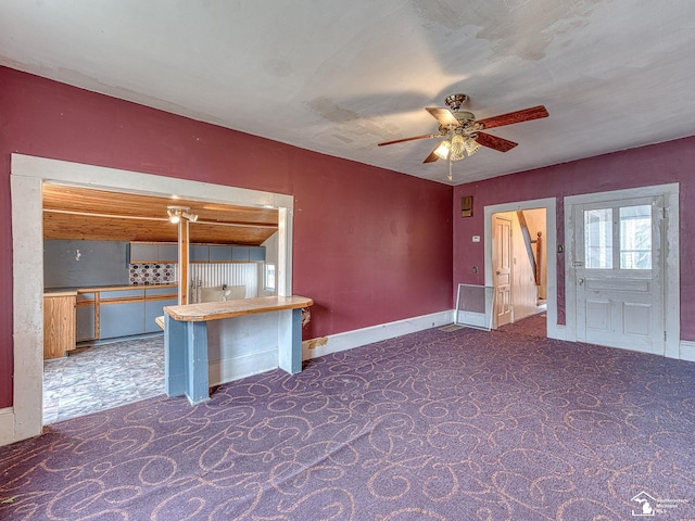 spare room featuring carpet floors, baseboards, and a ceiling fan