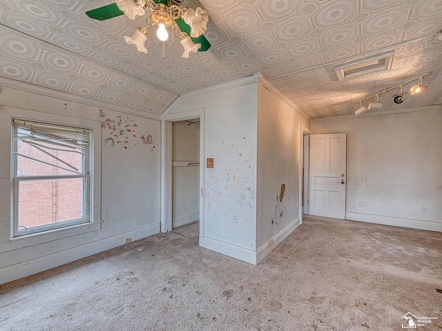 carpeted spare room with an ornate ceiling, visible vents, baseboards, and crown molding