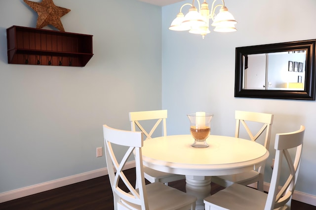 dining space featuring baseboards, a chandelier, and dark wood-type flooring