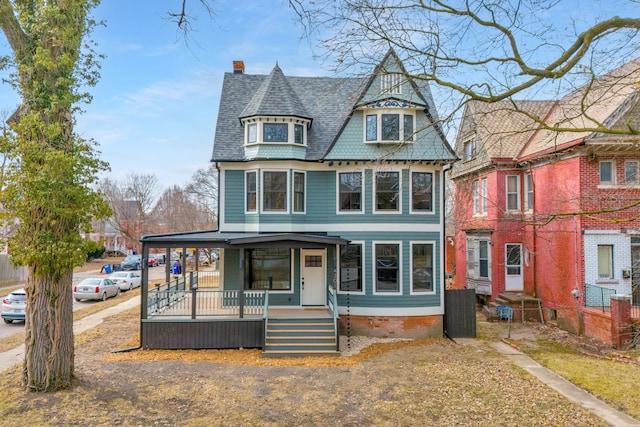 victorian home with covered porch and roof with shingles