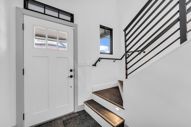 foyer entrance featuring plenty of natural light, stairs, baseboards, and wood finished floors