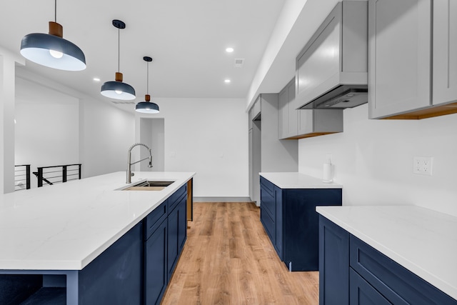 kitchen featuring blue cabinets, light countertops, and a sink