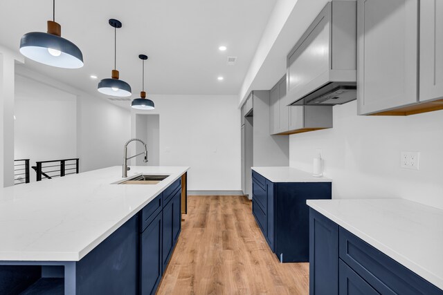 4301 Avery St, Detroit, MI 48208 - kitchen featuring a sink, blue cabinets, light wood finished floors, premium range hood, and recessed lighting