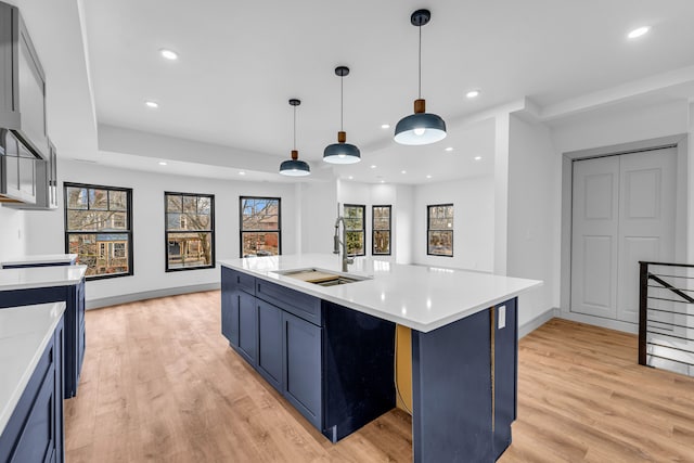 4301 Avery St, Detroit, MI 48208 - kitchen with a sink, light countertops, light wood-type flooring, blue cabinets, and recessed lighting