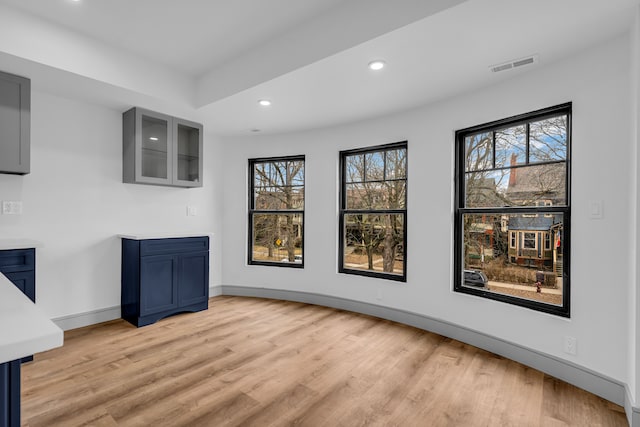 interior space with baseboards, light wood finished floors, visible vents, and recessed lighting