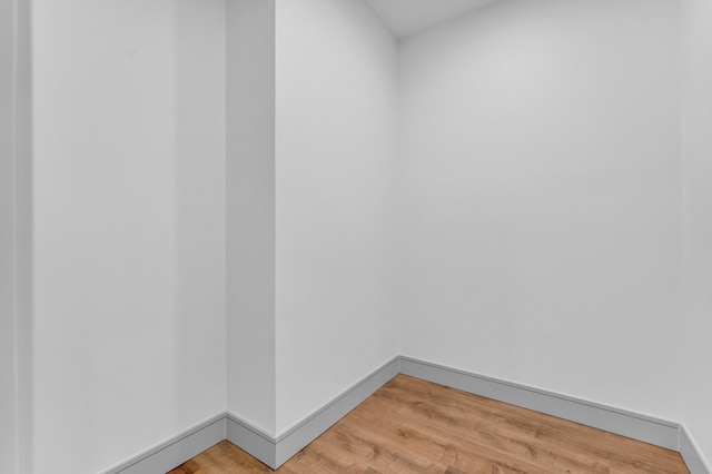 unfurnished room with light wood-type flooring and baseboards