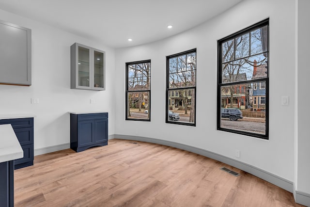 unfurnished dining area featuring light wood-style flooring, visible vents, baseboards, and recessed lighting