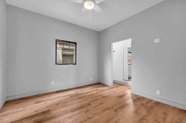 unfurnished room featuring a ceiling fan, baseboards, and wood finished floors