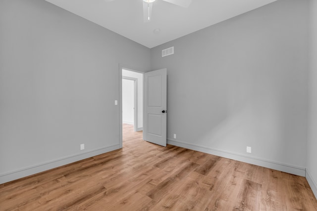 empty room with baseboards, visible vents, ceiling fan, and wood finished floors