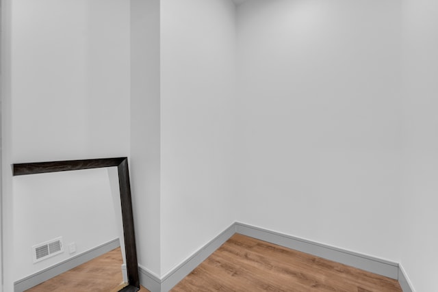 interior space featuring baseboards, visible vents, and wood finished floors