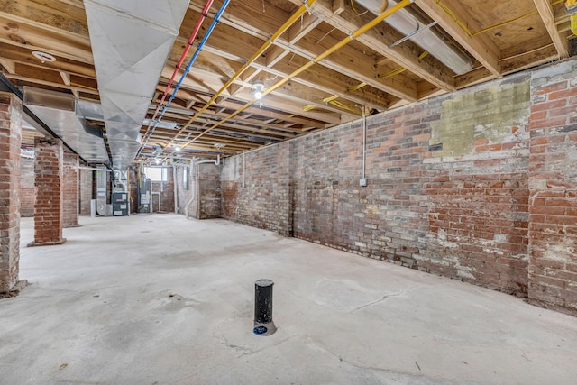 basement with water heater and brick wall