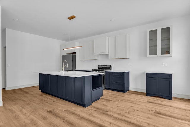 4301 Avery St, Detroit, MI 48208 - kitchen featuring stainless steel range with gas stovetop, freestanding refrigerator, light wood finished floors, light countertops, and baseboards